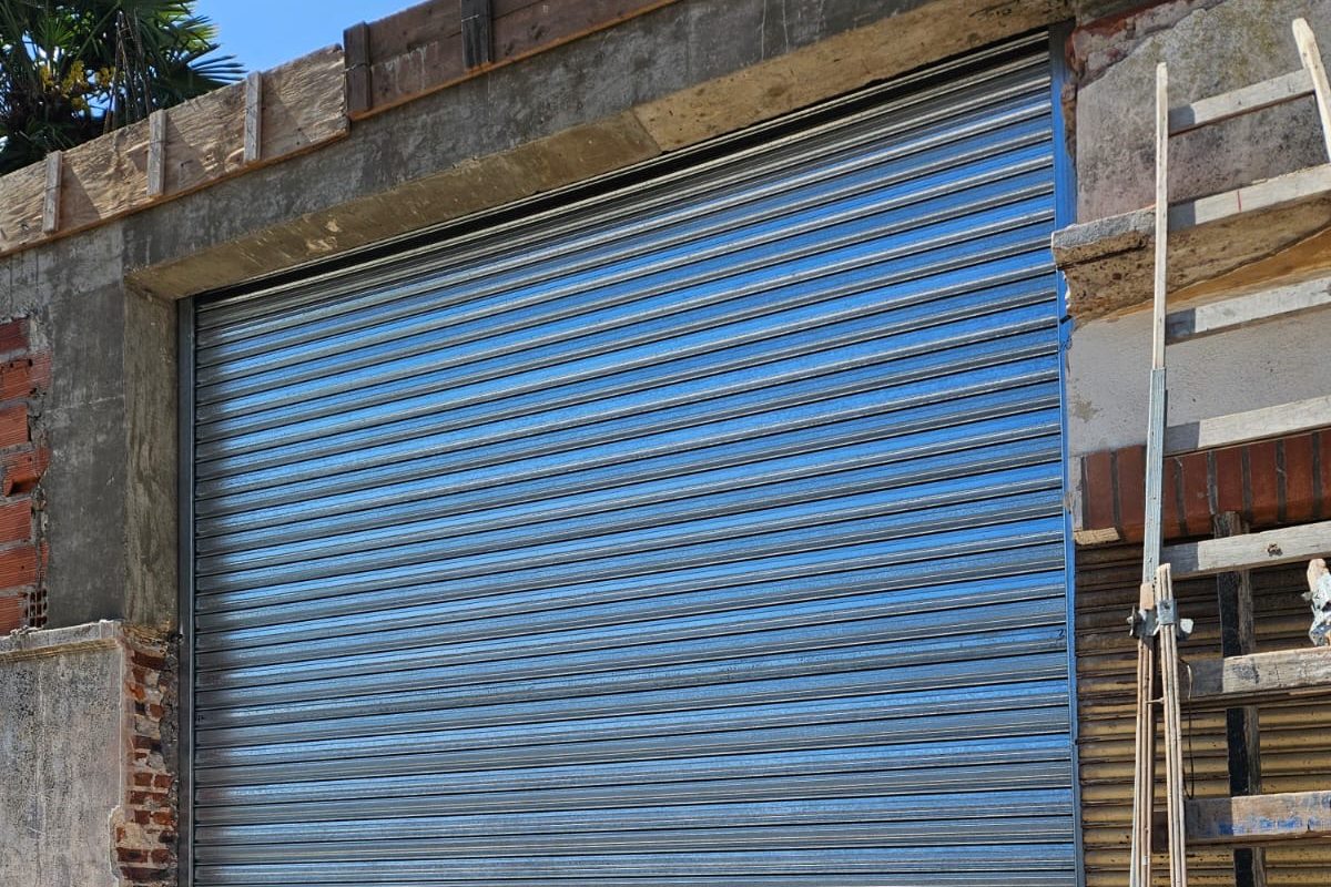 Cortina metálica de acero galvanizado recién instalada con etiquetas Colloni